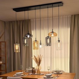 Elegant glass pendant luminaire with adjustable up and low lighting options in clear, amber, and smoke finishes.