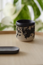 Black and white patterned ceramic mug with a simple, modern design.