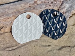  Orange translucent hand fan with a scenic coastal town in the background.