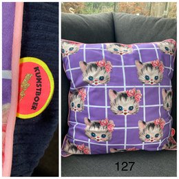  Plush cushion cover featuring a repeating pattern of cute kitten faces on a purple and white checkered background.