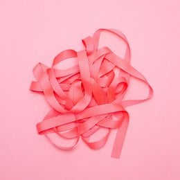 Neon pink ribbon with a text label "My Pretty Circus" on it. The ribbon appears to be made of a soft, flexible material and is coiled in a decorative manner.