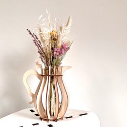 Tall, cylindrical vase made of wood with a natural finish, holding a bouquet of pink and red roses, dried flowers, and feathers.