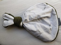 A green, button-embellished teddy bear with a propeller-like design, suitable for cuddling.