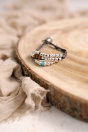 Charm bracelet with silver and colorful beads on a wooden surface.