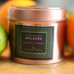 Bergamot-scented candle in a round, tall tin container with a copper-colored lid.