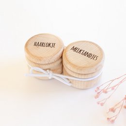 Wooden storage boxes for storing baby's first tooth and lock of hair, with engraved text "Haarlokie" and "Melktandje".