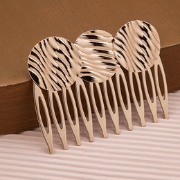 Wavy comb with a zebra-like pattern, designed for hair styling and grooming. Made of durable material, suitable for various hair types.