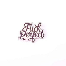 A black and white brooch with the text "Fuck Perfect" in a cursive font.