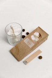 A DIY candle kit with a wooden wick, available in various scents like fig, caramel, clean linen, floral garden, and sea salt.