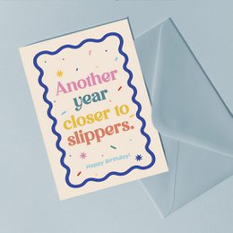  Birthday card with slippers text, colorful wavy border design, cream and blue colors, humorous greeting card