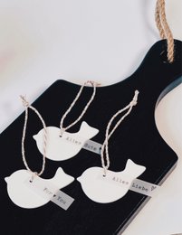 Delicate porcelain pendant with bird motif, perfect for Easter decor. Neutral tones and natural materials create a rustic, minimalist aesthetic.