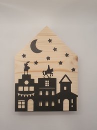 Wooden Sinterklaas house ornament with silhouettes of houses, a crescent moon, and stars.