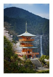 A traditional Japanese pagoda nestled in a lush, mountainous landscape with a waterfall in the foreground.
