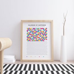 A colorful calendar with a simple, minimalist design featuring a grid of multicolored shapes. The calendar is titled "Calendar of Happiness" and appears to be available in multiple languages including English, German, Spanish, Russian, French, Latvian, and Italian.