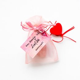 A pink organza bag containing a heart-shaped crystal, with a tag that says "You are my heart". The crystal has a soft, natural appearance and is surrounded by a delicate pink bow.