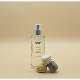 Floral, sweet-scented room spray with notes of macaroon. Pale pink liquid in a glass bottle with a silver spray nozzle. Accompanied by colorful macaroon pastries.