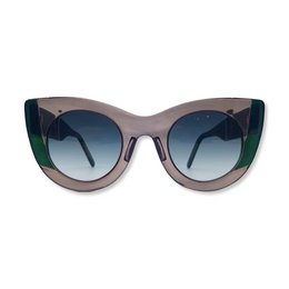 Oversized cat-eye sunglasses with a two-tone frame in gray and green. The lenses have a gradient blue tint.