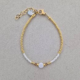 Gold and silver beaded bracelet with white stone accent, delicate minimalist design, adjustable chain closure.