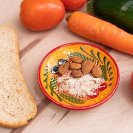 Ceramic grater plate in a vintage Spanish/Provencal red color, featuring a decorative design with vibrant colors and patterns. The plate is multifunctional and available in various sizes, suitable for grating, serving, or displaying food items.