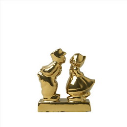 A gold-colored statue depicting a kissing couple. The statue has a stylized, abstract design with the figures appearing to be embracing or kissing.