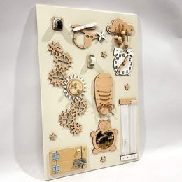 Beige busy board with various shapes, textures, and activities for sensory exploration and development.