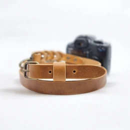 Camel-colored leather camera belt with silver and old brass hardware. Adjustable length for a comfortable fit.