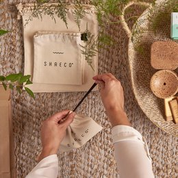 Beige cotton carry-on bag with "SHAECO" printed on it. Suitable for weekend travel.
