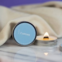 Mini scented soy candles in cotton fragrance. Round, tall candle with a soft, creamy color.