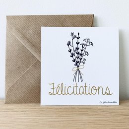 A card with a hand-drawn bouquet of flowers and the text "Felicitations" written in a cursive font. The card is accompanied by a brown envelope, suggesting it is a greeting card or congratulatory card.