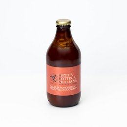 Tomato sauce in a glass bottle with a red label. The sauce is a deep red color and the bottle has a metal cap.