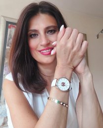 Silver-toned round watch with leather strap and gold-toned accents.