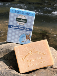Organic goat milk and honey soap bar with a natural, handmade appearance. Features a rectangular shape and light tan color.