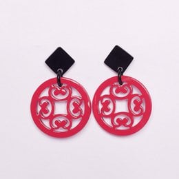 Vibrant, statement earrings featuring a bold, circular design in a bright pink color. The earrings have a modern, geometric style with a cutout pattern that adds visual interest. These earrings would be a stylish accessory for any fashion-forward outfit.