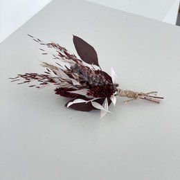 Elegant burgundy brooch with dried eucalyptus leaves and twigs, perfect for a wintry look.
