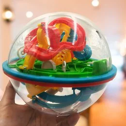 A colorful, spherical maze toy with various shapes and textures inside a transparent ball.