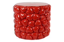  A round, red stool with a heart-shaped pattern. The stool has a wooden top and a base made of red heart-shaped pieces.