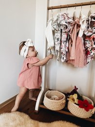 Pink ruffled muslin top for baby and toddler girls, available in sizes 3m to 18m. Features angel sleeves and a soft, lightweight fabric perfect for summer.