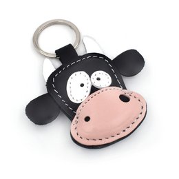 Handmade leather cow keychain with a cute, whimsical design featuring large eyes and a pink nose. The keychain has a sturdy metal ring for attaching to keys or bags.