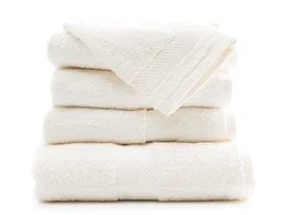 Ivory-colored bath towels in various sizes, including 90x170 cm, 65x125 cm, 50x100 cm, 40x70 cm, Washandje, and 30x30 cm. The towels have a soft, plush texture and a simple, elegant design.