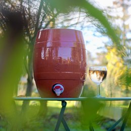Terracotta storage jar with a round, barrel-shaped design and a spigot for dispensing contents. Available in natural and white color variants.