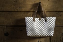 Large white and gray patterned tote bag with brown leather handles, made from recycled materials, suitable for shopping or beach use.