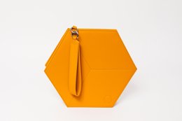 Bright yellow hexagonal clutch with a wrist strap.