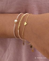 A delicate gold-toned bracelet featuring a small heart charm, available in gold, silver, and rose gold finishes. This minimalist charm bracelet is perfect for everyday wear.