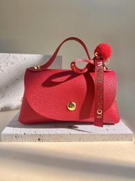  Elegant, chic gift bag in vibrant red color with pom-pom charm and adjustable strap.