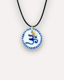 Blue porcelain Om charm pendant with gold-tone metal accents.