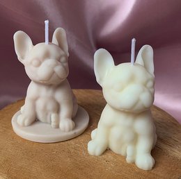 Pair of round, tall, white candles in the shape of French bulldog dogs. The candles have a simple, minimalist design and appear to be made of a wax or similar material.