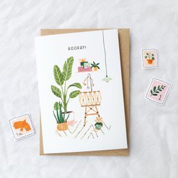 "Hurrah! Cradle" - A colorful baby card featuring a crib, plants, and a celebratory message. The card is suitable for a variety of baby-related occasions.