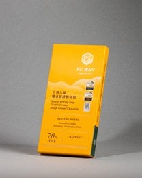 Dark chocolate bar with 70% cacao content, featuring a rough ground texture and double fermentation process for a bold, complex flavor profile.