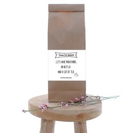 A brown paper bag with the text "QuoTEs Netflix Marathon" printed on it, containing a tea product.