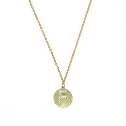 Gold-toned necklace with diamond-shaped pendant featuring the initial 'F'.